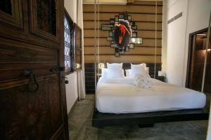 a bedroom with a bed with white sheets and pillows at Hotel Boutique Patio del Posadero in Córdoba