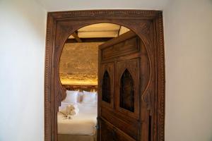 a wooden doorway to a bedroom with a bed at Hotel Boutique Patio del Posadero in Córdoba