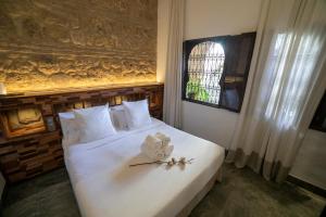 a bedroom with a white bed with flowers on it at Hotel Boutique Patio del Posadero in Córdoba
