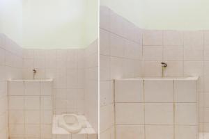 La salle de bains est pourvue de carrelage blanc, de toilettes et d'un lavabo. dans l'établissement Hotel O Pondok Wisata Kaliandra Kaliurang, à Yogyakarta