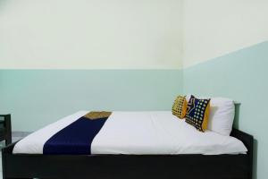 un lit avec deux oreillers dessus dans une chambre dans l'établissement Hotel O Pondok Wisata Kaliandra Kaliurang, à Yogyakarta 2 autres photos