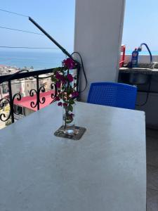 a vase with purple flowers sitting on a table at Room in Erdemli