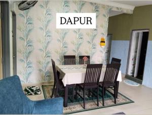 a dining room with a table and chairs in a room at Odah Homestay in Bedung