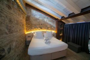 a bedroom with a large bed with a stone wall at Hotel Boutique Patio del Posadero in Córdoba