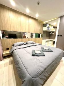 a bedroom with a large bed with a tv on the wall at The Prim Grand Condo Wongamat N103 - Spacious apartment near the sea in Pattaya North +36 photos