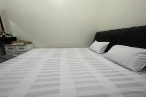 a bedroom with a bed with a black headboard and two pillows at Hotel O Anda Kost 2 Near Lapangan Syech Yusuf Discovery in Sungguminasa