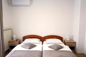 two twin beds in a room with two night stands at Studio Apartman Šafranko in Krapinske Toplice