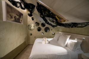 a bedroom with a white bed with decorations on the wall at Hotel Boutique Patio del Posadero in Córdoba