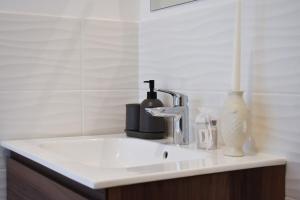 a bathroom sink with a faucet and a vase at Renovated villa 400 meters from the sea with garden in Forte dei Marmi +13 photos