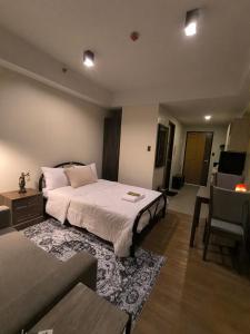 a bedroom with a large bed and a couch at The Serena Suite in Manila