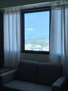 a window with a couch in a room with a view at The Serena Suite in Manila