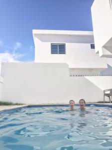 two men in a swimming pool in a house at Villa Muñoz in San Felipe de Puerto Plata