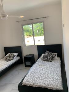 a bedroom with two beds and a window at Villa Muñoz in San Felipe de Puerto Plata