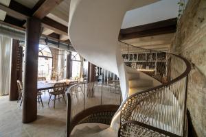 a spiral staircase in a restaurant with chairs and a table at Hotel Boutique Patio del Posadero in Córdoba
