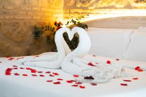 a bed with two swans in the shape of hearts at Hotel Boutique Patio del Posadero in Córdoba