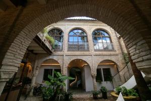 an archway of a building with windows and plants at Hotel Boutique Patio del Posadero in Córdoba