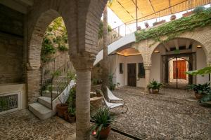 an indoor courtyard of a building with arches and plants at Hotel Boutique Patio del Posadero in Córdoba
