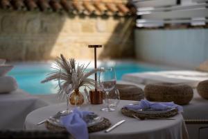 a table with two glasses and a palm plant on it at Hotel Boutique Patio del Posadero in Córdoba