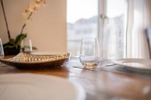 a wooden table with two glasses and plates on it at Inselzeit Comfort Suites SELLIN in Ostseebad Sellin