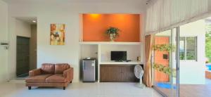 a living room with a chair and a refrigerator at Baan Pare in Pran Buri