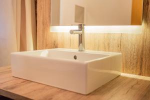 a white sink in a bathroom with a mirror at Inselzeit Comfort Suites SELLIN in Ostseebad Sellin