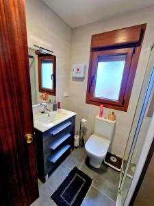 a bathroom with a toilet and a sink and a window at VV Casa Leonor in Asiego +16 photos