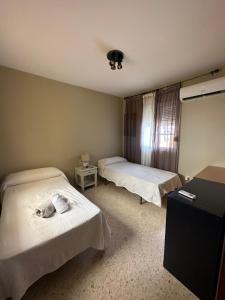una camera d'albergo con due letti e una scrivania di Apto dos dormitorios en Ayacosta a Isla Canela