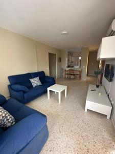 un soggiorno con un divano blu e un tavolo di Apto dos dormitorios en Ayacosta a Isla Canela