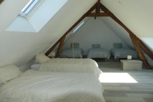 a attic room with three beds and a window at La Maison de Mémé gîte 14 pers aux portes de la Baie de Somme in Tours-en-Vimeu