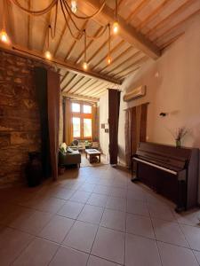 a living room with a piano in the middle of a room at auberge des trois ami-es in Vinezac