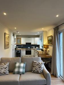 a living room with a couch and a kitchen at Cologin in Oban