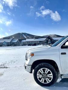 a white truck parked in a snow covered field at Appi Life is Beautiful in Hachimantai