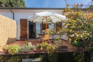 カポリーヴェリにあるCasa I Due Golfi, Vista Mare Unica!の傘とテーブルと椅子のあるパティオ