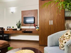 a living room with a tv on a wooden cabinet at Your 2nd Home Studio Haven in Dehradun