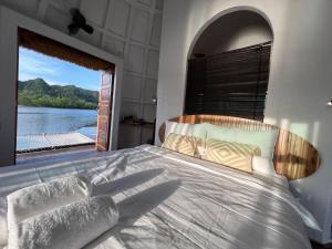 a bedroom with a large bed with a large window at Coconest ONE Langkawi in Tanjung Rhu