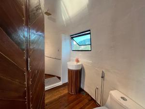 a small bathroom with a toilet and a window at Coconest ONE Langkawi in Tanjung Rhu
