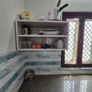 a kitchen with a shelf with tiles on it at Leela homestay - one Bedroom with kitchen in Jabalpur