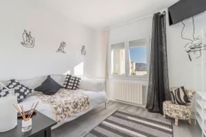 a white living room with a couch and a window at Casa pablo y francisca in Alfarrás