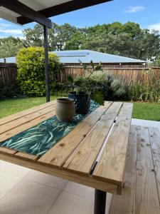 a wooden picnic table with a vase sitting on it at Wittus Retreat in White River