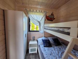 a bedroom with two bunk beds and a window at Białe Domki in Sarbinowo +40 photos