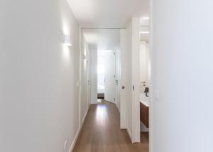 ヴィアナ・ド・カステロにあるMexia Galvão city centerの白い壁と木の床の廊下