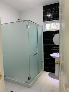 une salle de bain avec une douche en verre et un lavabo dans l'établissement Oville Tagaytay- Cozy and Senior Friendly House, à Tagaytay 18 autres photos