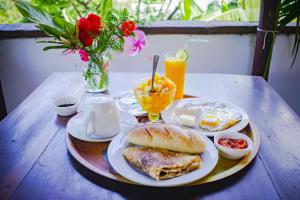 a table with a plate of breakfast food on it at Hotel Les Boucaniers in Ambatoloaka