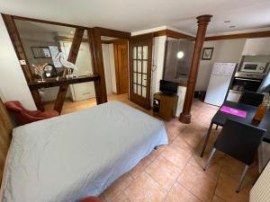 a bedroom with a white bed and a kitchen at Apartment Cali Elina in Riquewihr