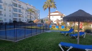 een resort met een zwembad en stoelen en een gebouw bij La Cala Mijas Cozy Apartment in La Cala de Mijas
