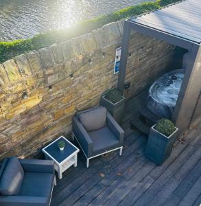 an overhead view of a deck with a couch and a table at Couples Canalside Retreat with Hot Tub & Pergola in Poynton