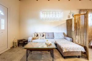 a living room with a couch and a table at Petalidi Sunny Home Two - Cozy Garden Escape in Petalidi