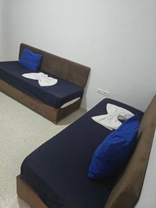 two beds in a room with blue pillows at Appartements BAYA in Mezraya