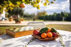 a basket of fruit on a table with a chessboard at Petalidi Sunny Home Two - Cozy Garden Escape in Petalidi +32 photos