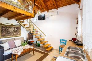 a kitchen and living room with a spiral staircase at Petalidi Sunny Home One - Charming Garden Nest in Petalidi